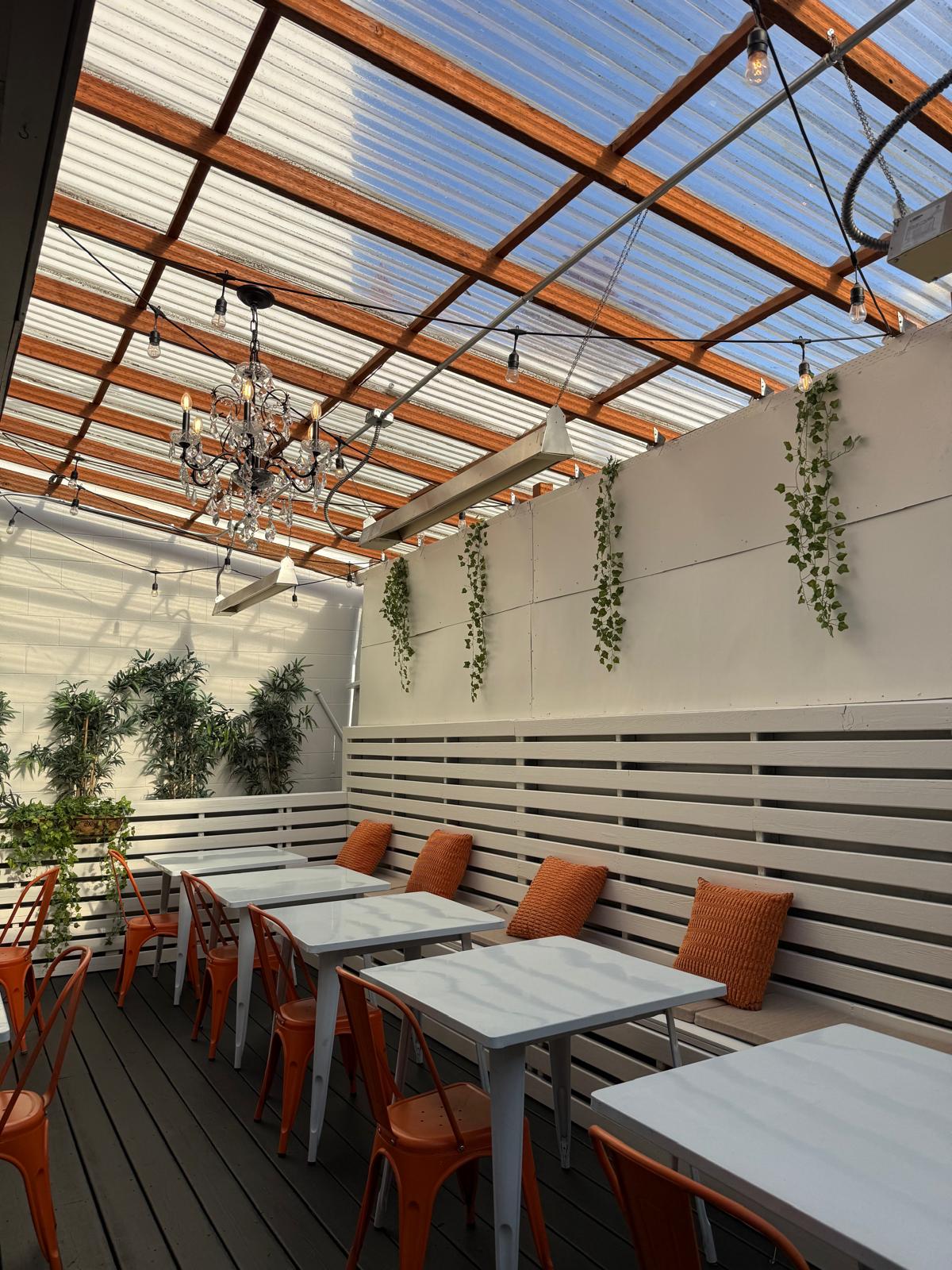 Patio with chandelier and orange Tolix chairs
